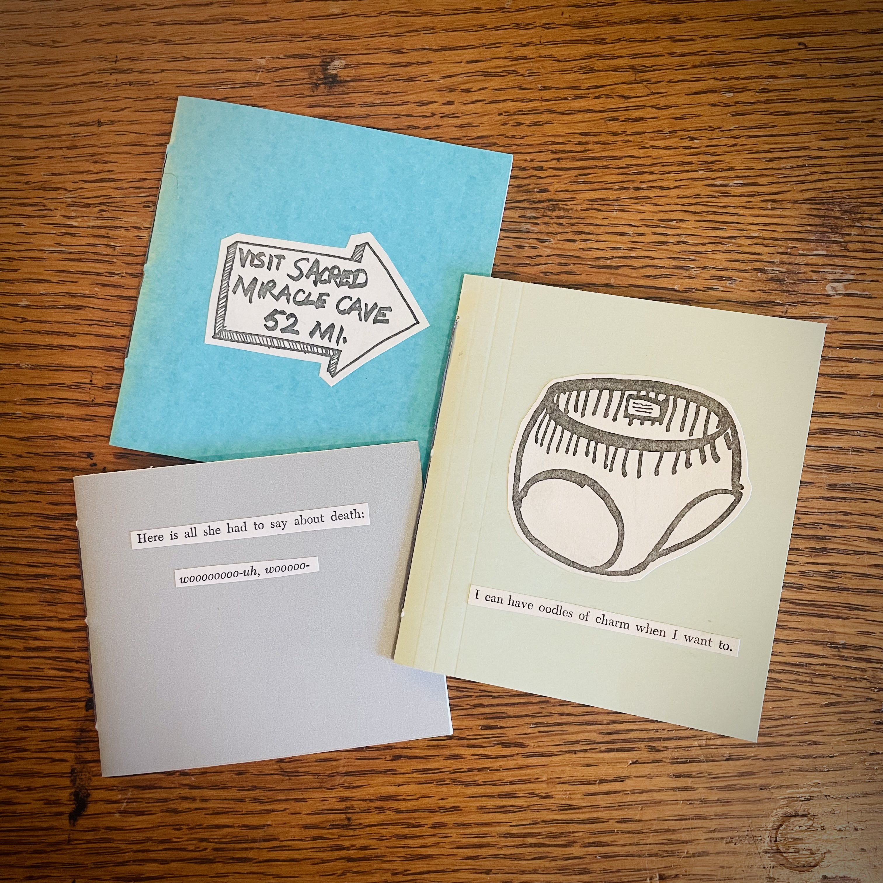 Three motebooks, each with an image cut out from Kurt Vonnegut's Breakfast of Champions on the cover.